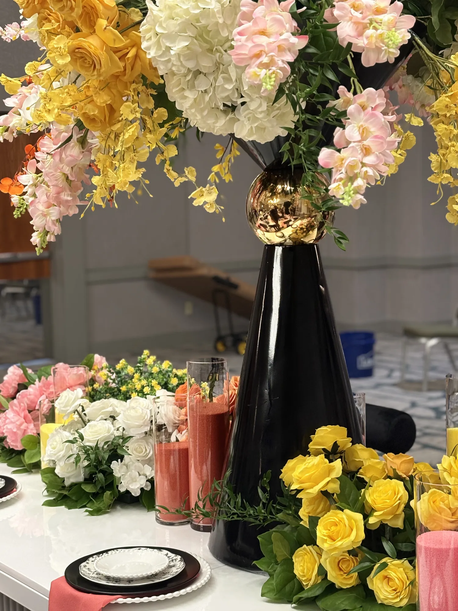 A tall floral centerpiece going up in the ballroom before doors open