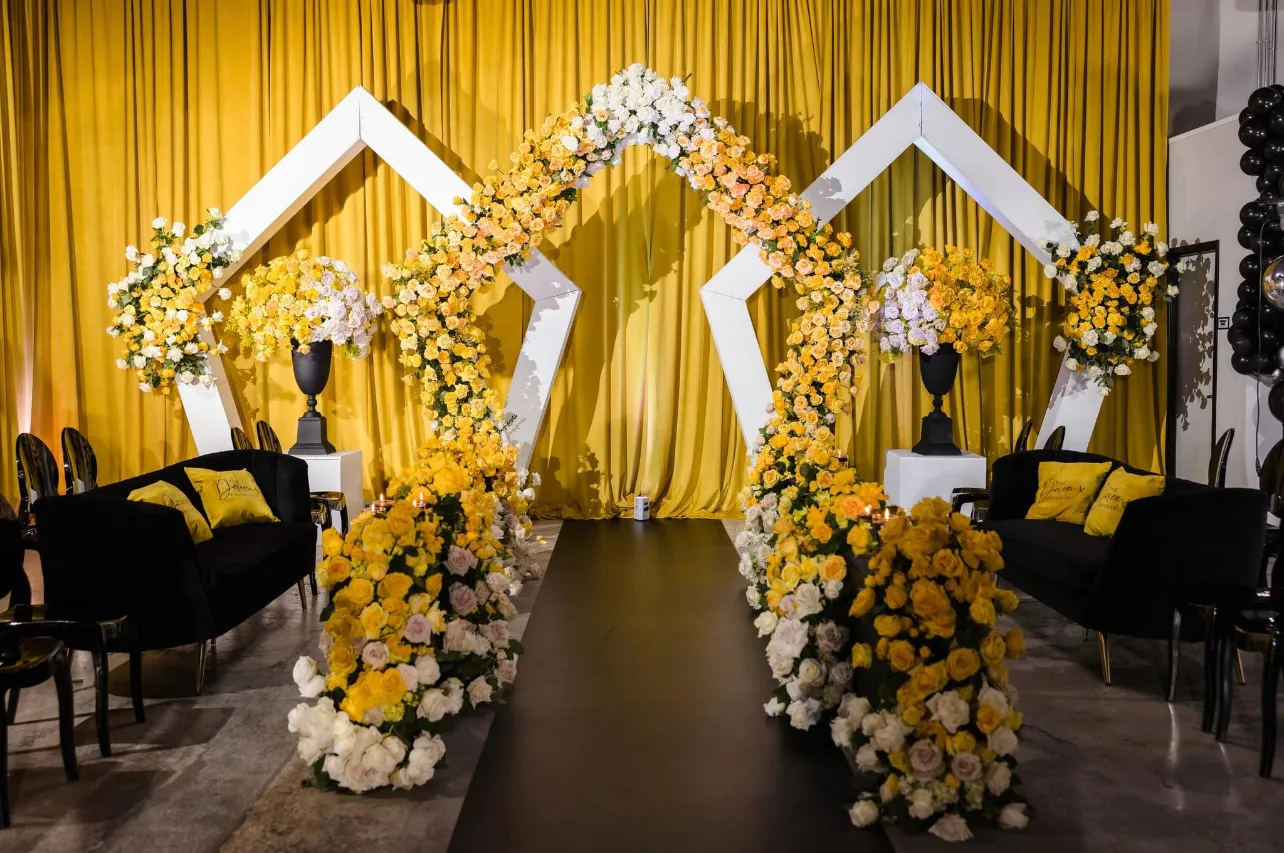 Gold and white ceremony arch by Greystone Design Co.