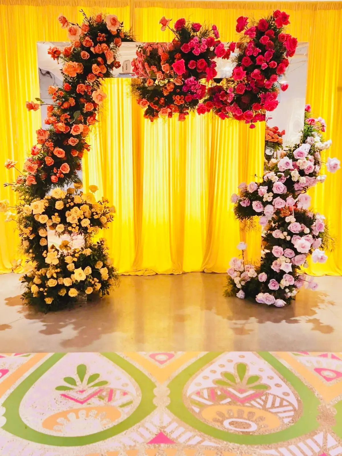 Red and gold floral arch by Greystone Design Co.