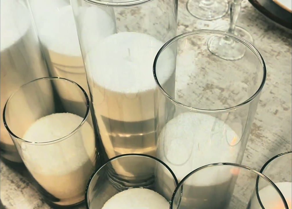 Candle vessels being styled on a tablescape for a Greystone event